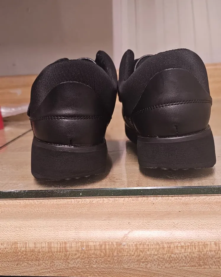 Rear view of a pair of black shoes with lateral wedges